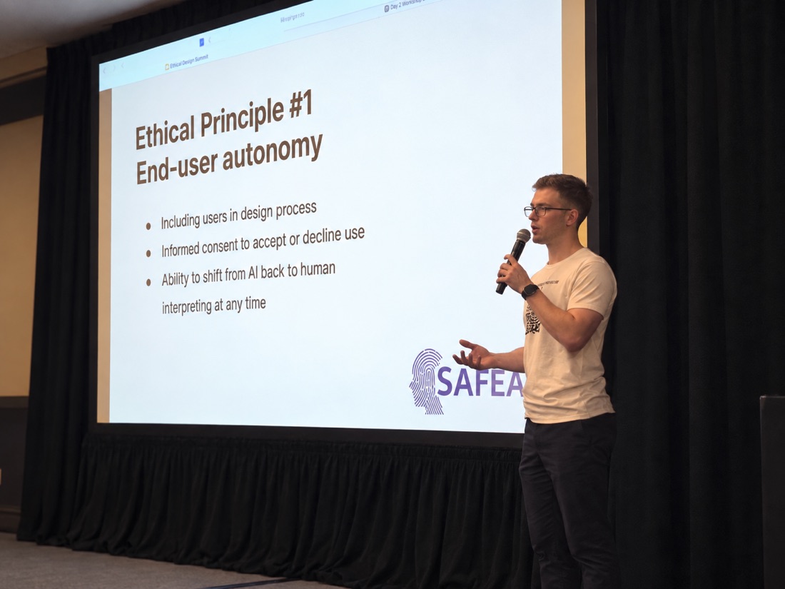 Olivier speaking at UXPA beside a slide about end-user autonomy in AI interpreting